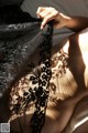 A woman laying on top of a bed covered in black lace.