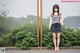 A woman standing in front of a chain link fence.