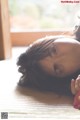 A woman laying on the floor looking at the camera.