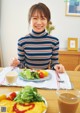 A woman sitting at a table with a plate of food.