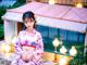 A woman in a pink kimono sitting on a ledge.