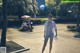 A naked woman walking down a sidewalk at night.