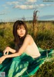 A woman sitting in a field of tall grass.